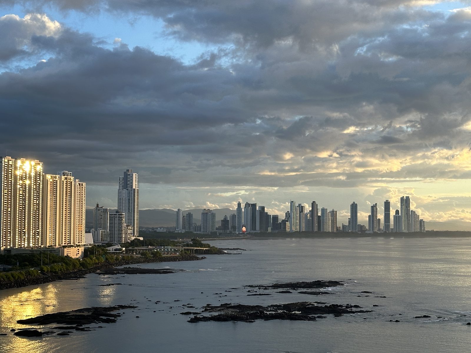 Panama City towers along the shoreline under evening clouds